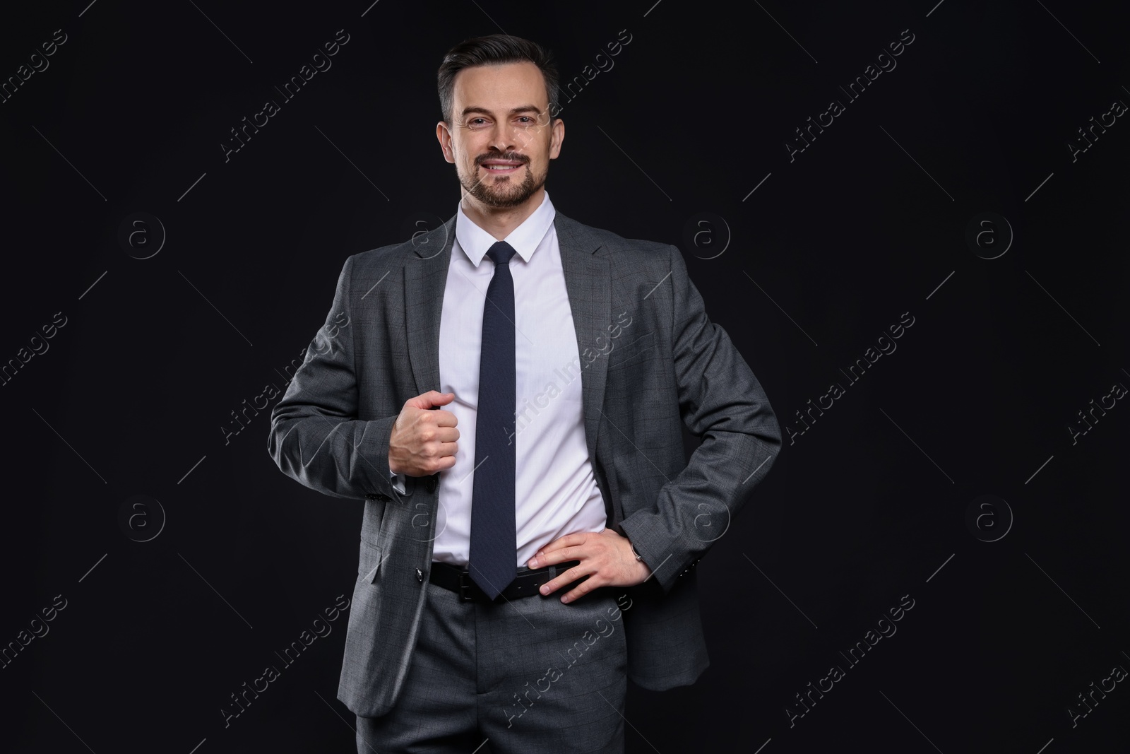 Photo of Confident man in classic suit on black background