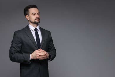 Confident man in classic suit on grey background