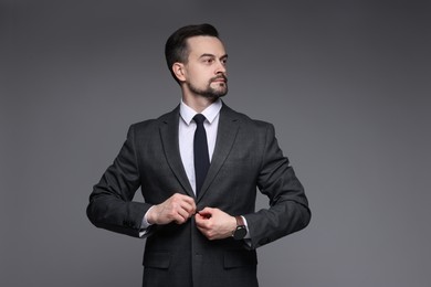 Confident man in classic suit on grey background