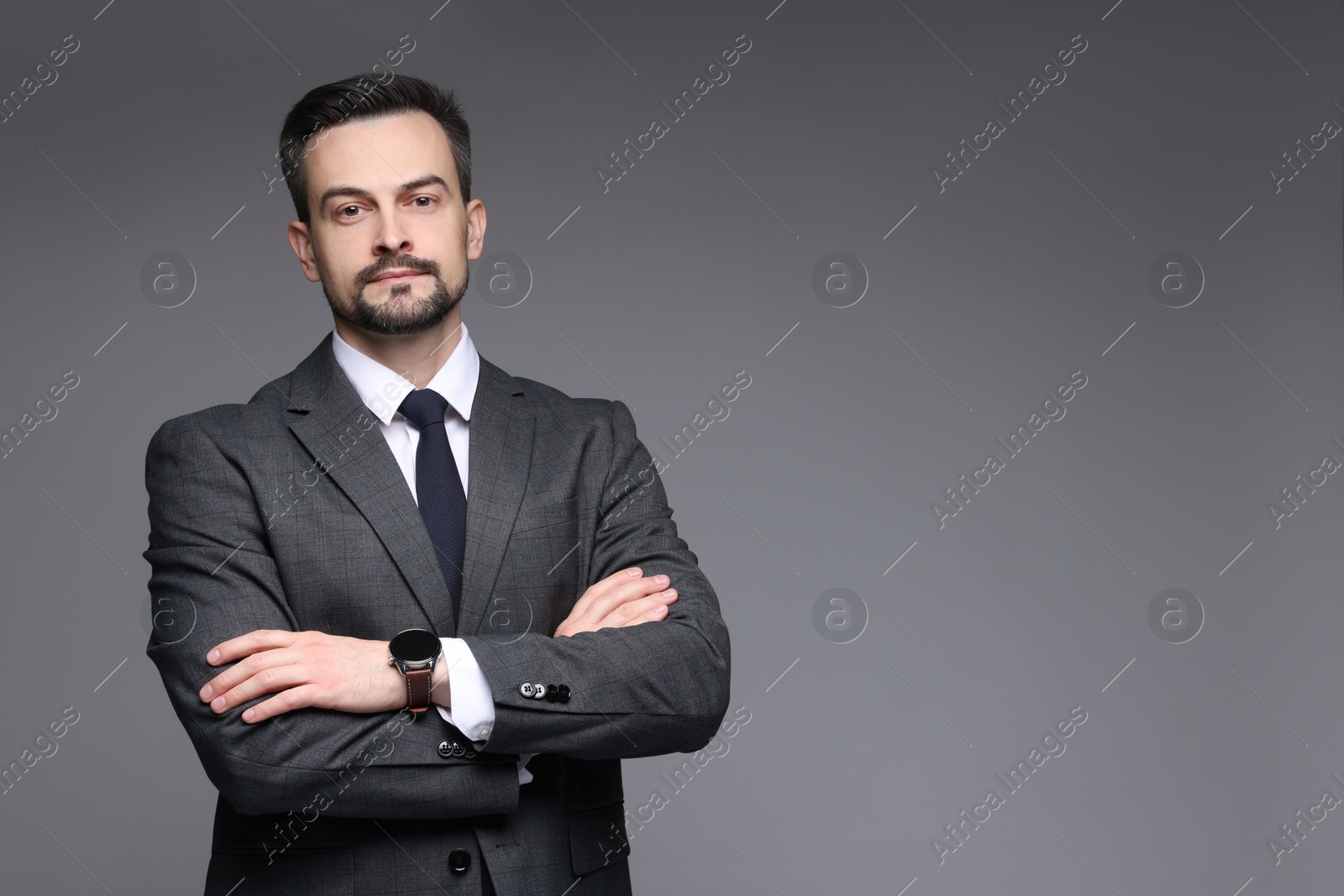 Photo of Confident man in classic suit on grey background. Space for text