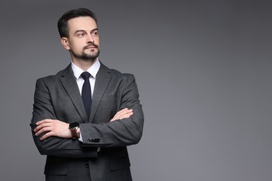 Photo of Confident man in classic suit on grey background. Space for text