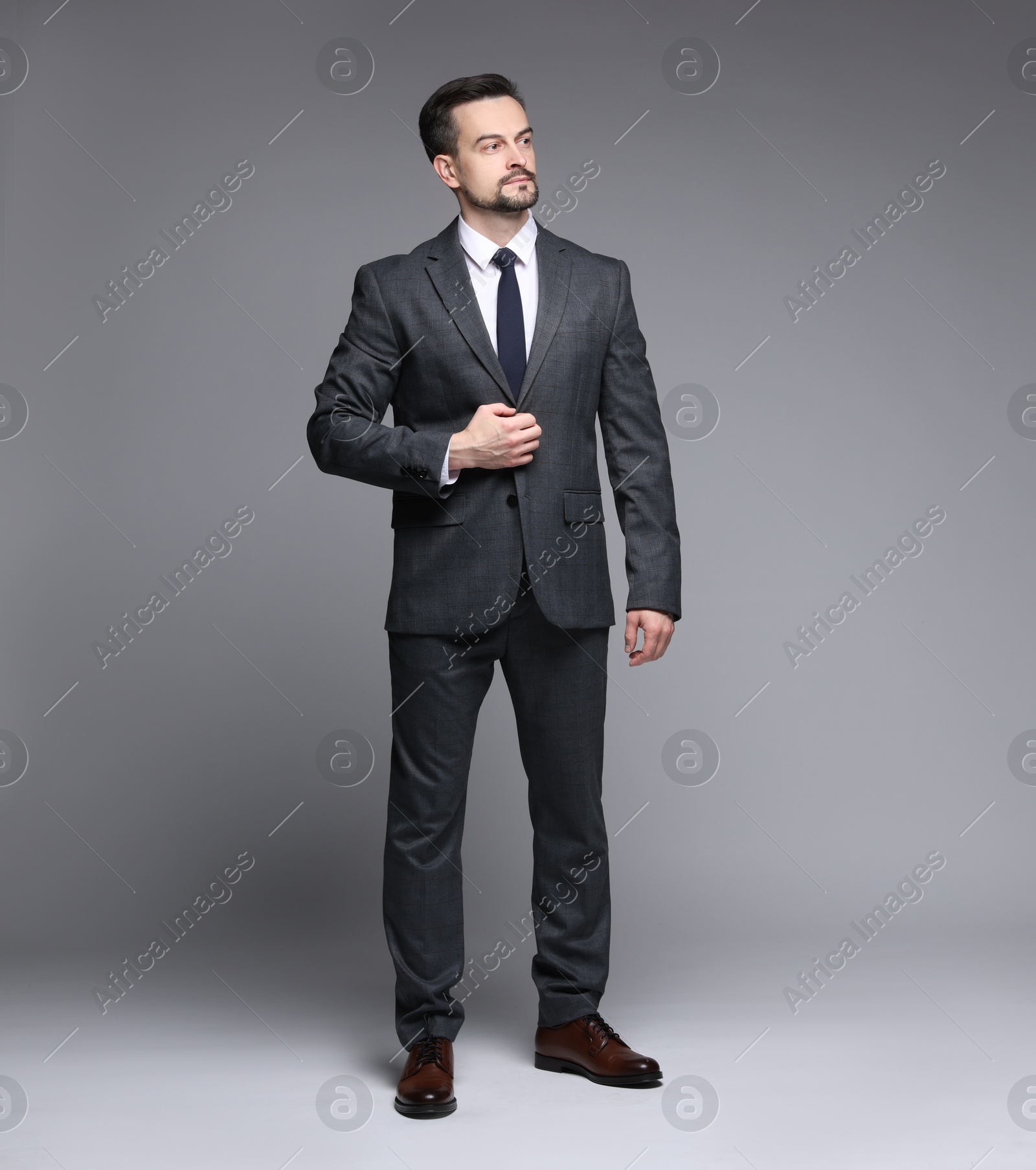 Photo of Confident man in classic suit on grey background