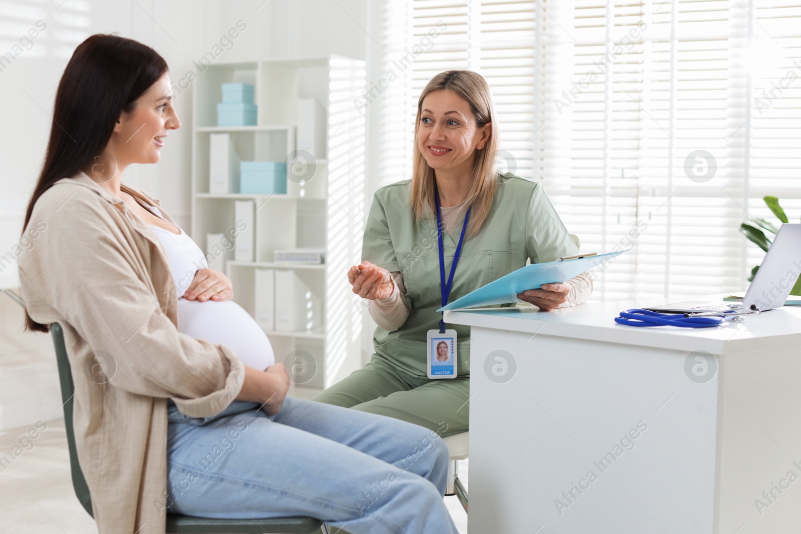 Photo of Pregnant woman having appointment with doctor in clinic