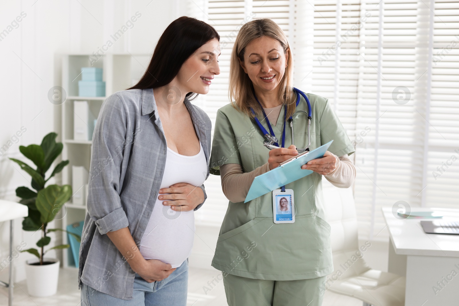 Photo of Pregnant woman having appointment with doctor in clinic