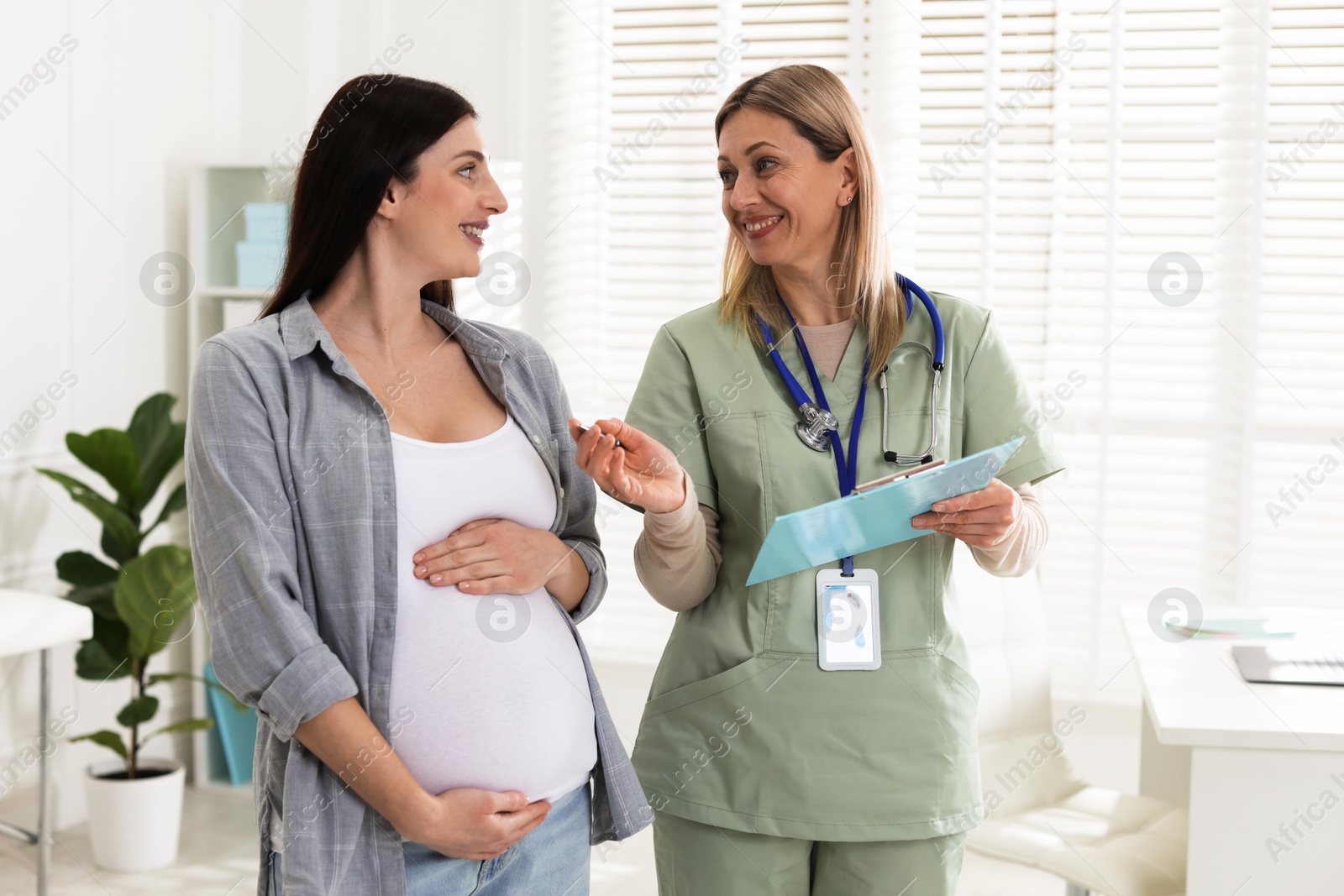 Photo of Pregnant woman having appointment with doctor in clinic