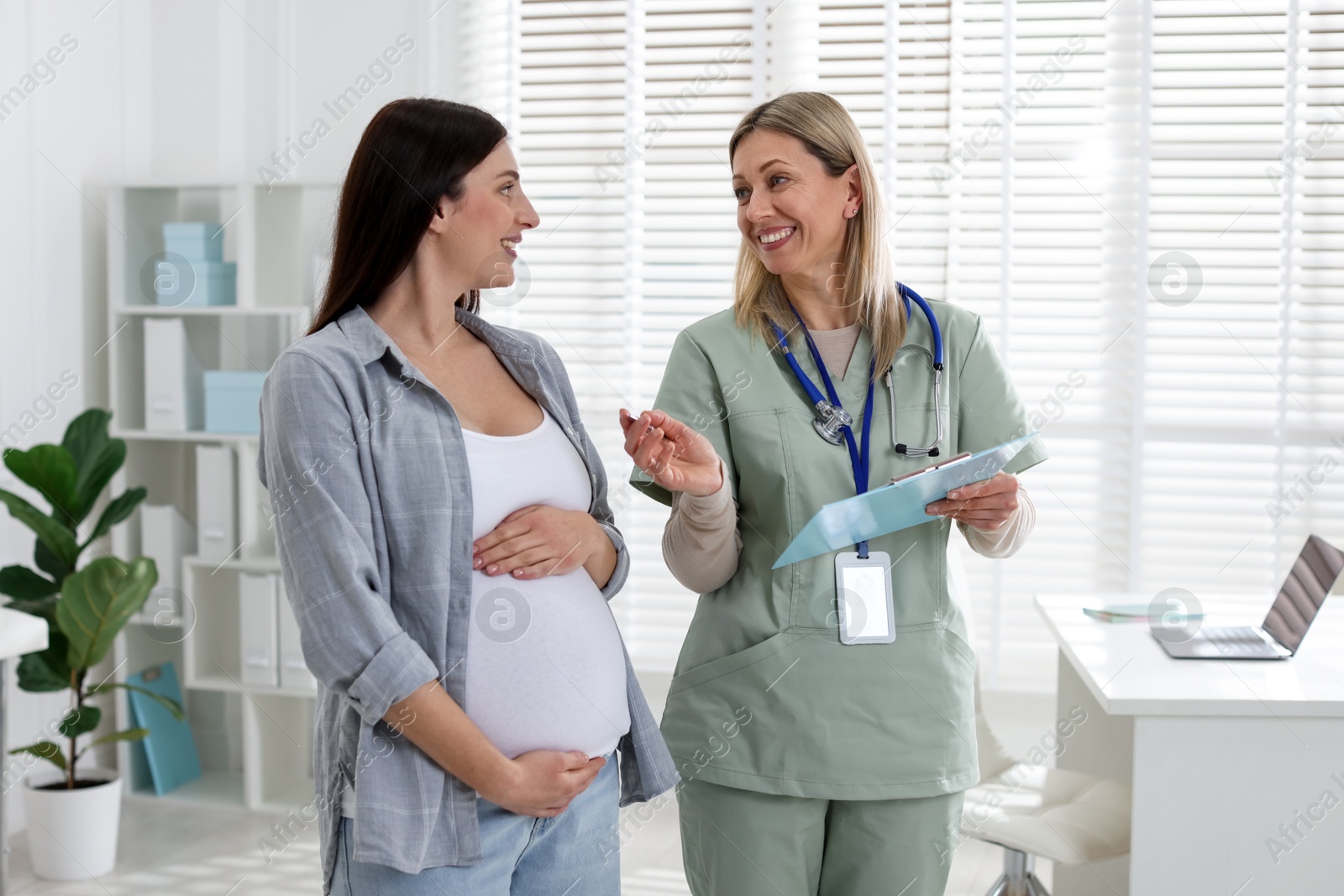 Photo of Pregnant woman having appointment with doctor in clinic