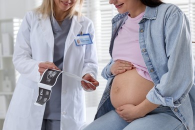 Photo of Pregnant woman having appointment with doctor in clinic, closeup