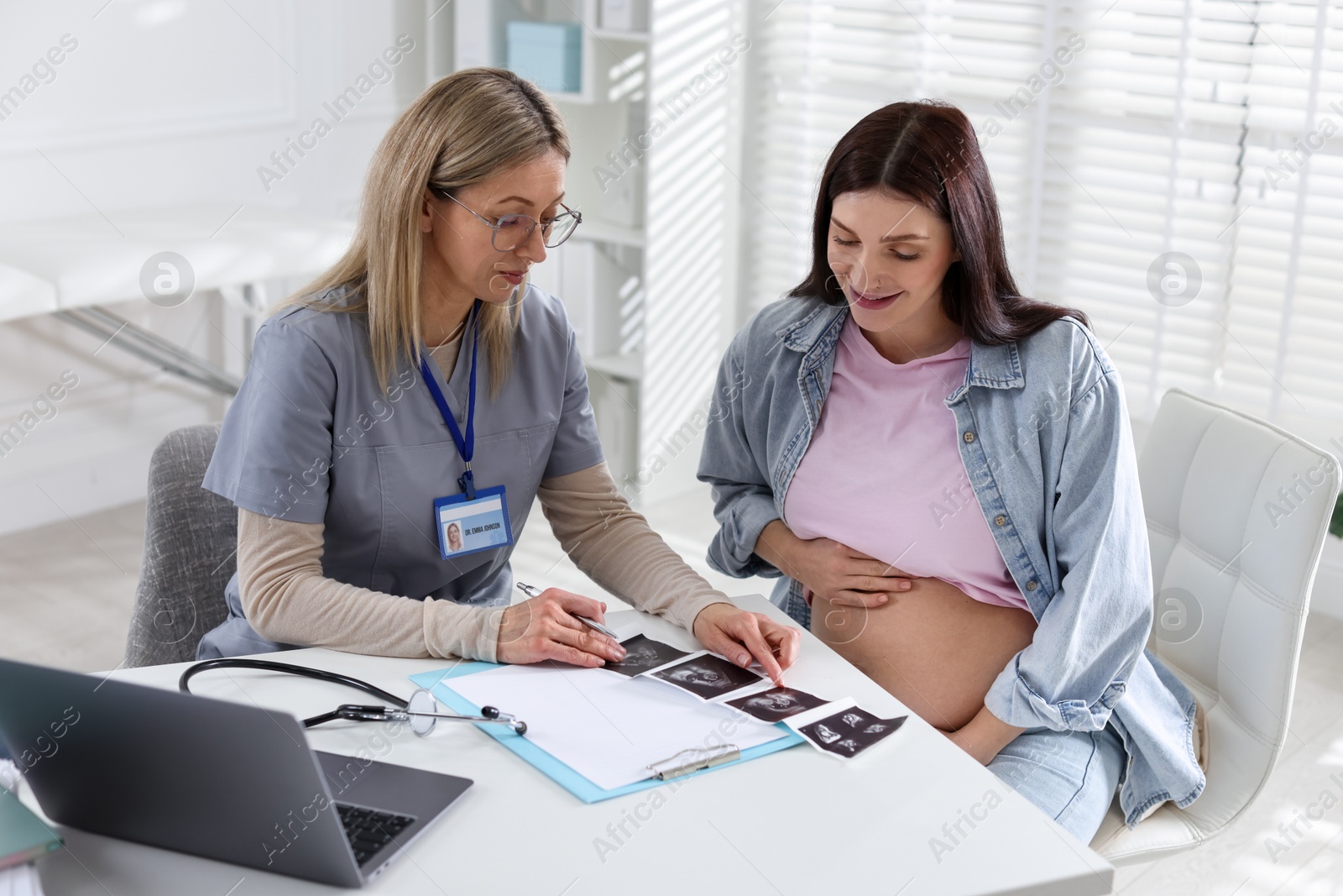 Photo of Pregnant woman having appointment with doctor in clinic