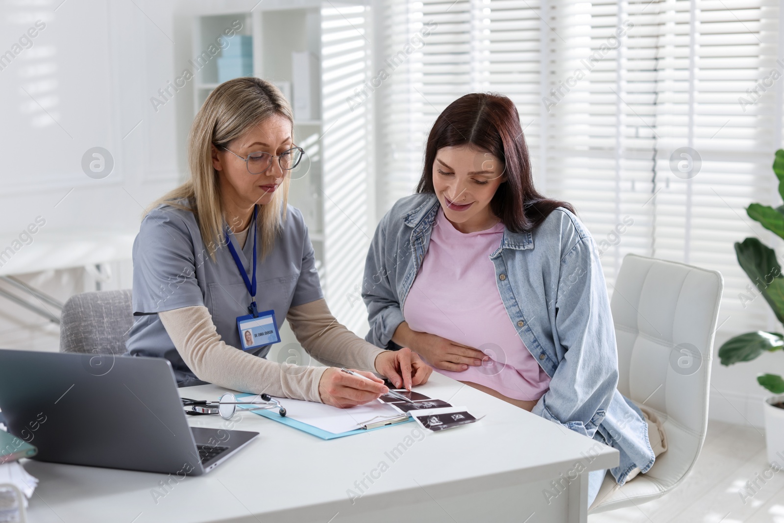 Photo of Pregnant woman having appointment with doctor in clinic