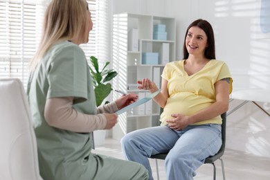 Photo of Pregnant woman having appointment with doctor in clinic