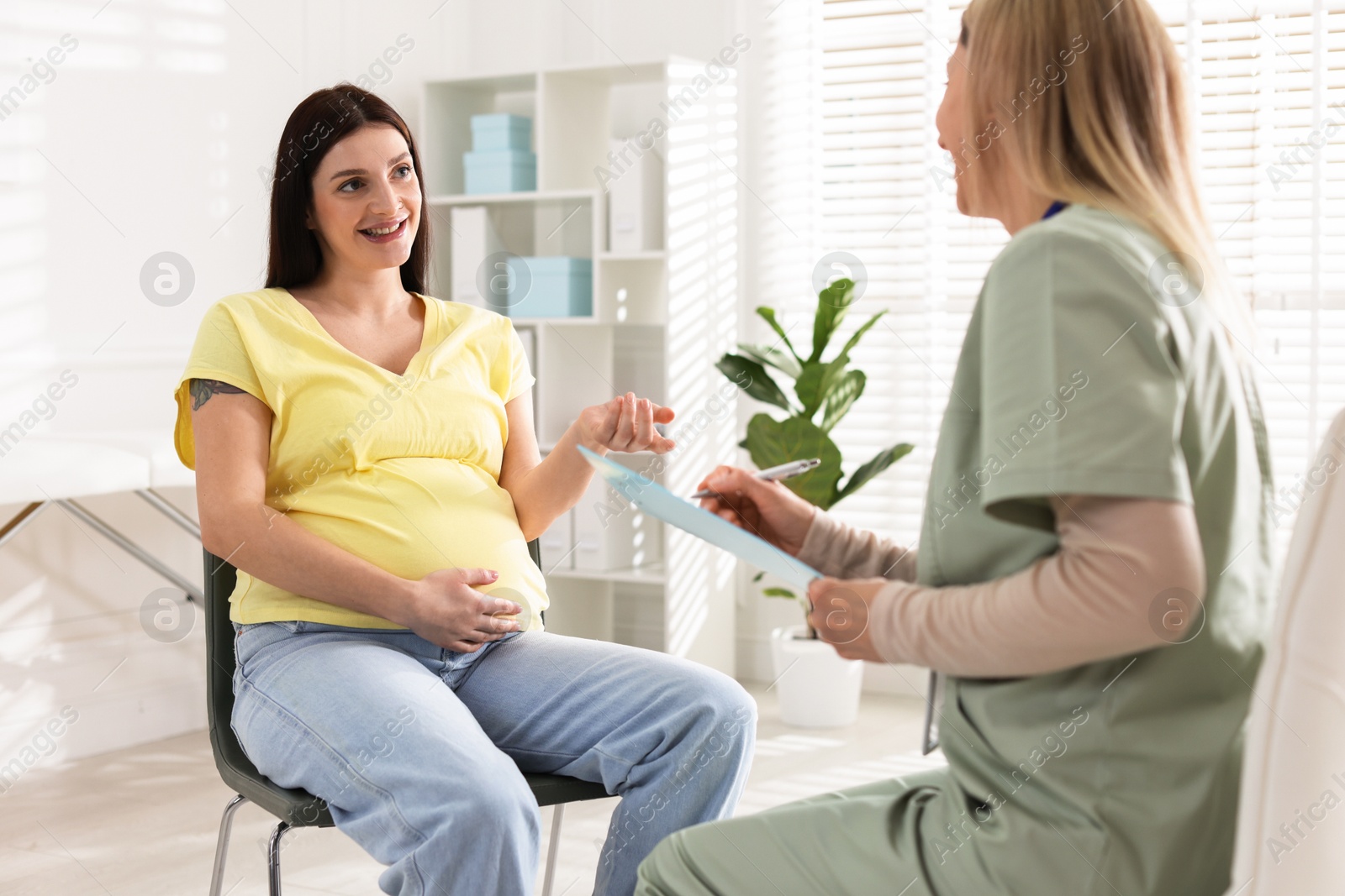 Photo of Pregnant woman having appointment with doctor in clinic