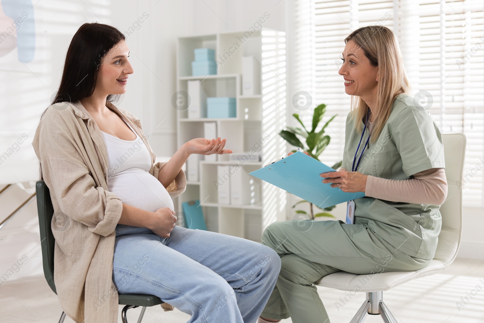 Photo of Pregnant woman having appointment with doctor in clinic