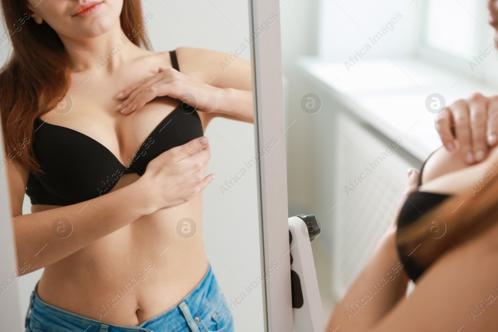 Photo of Woman wearing beautiful bra near mirror indoors, closeup