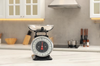 Photo of Retro mechanical kitchen scale on white marble table indoors, space for text