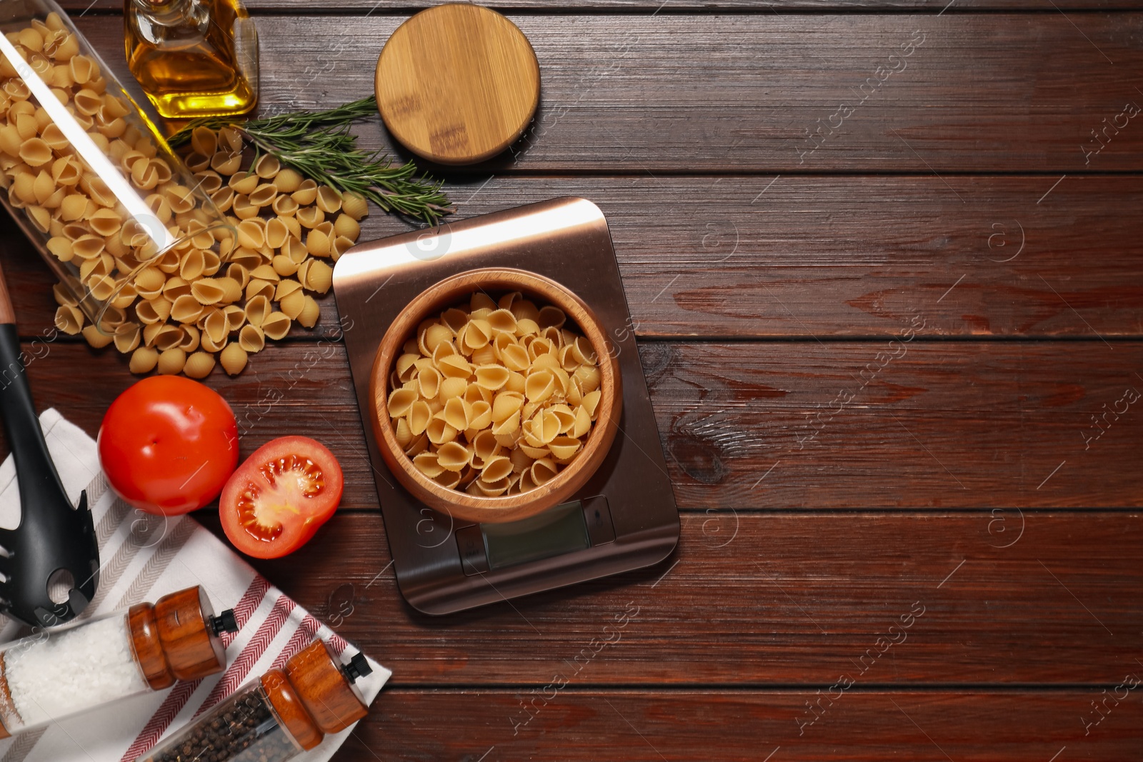 Photo of Electronic kitchen scale and products on wooden table, flat lay. Space for text