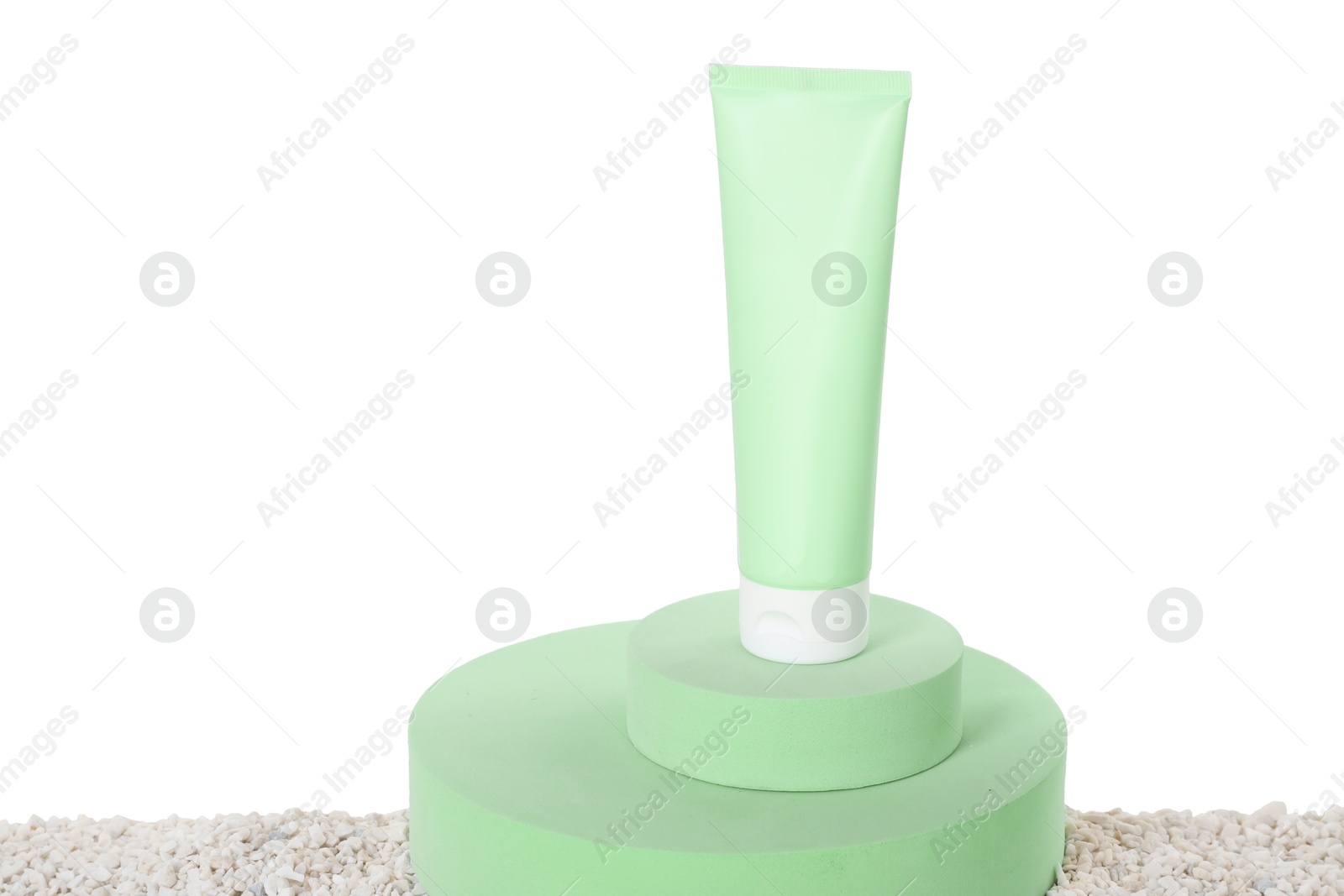 Photo of Tube of sun protection product and podiums on pebbles against white background