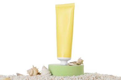 Tube of sun protection product and seashells on pebbles against white background