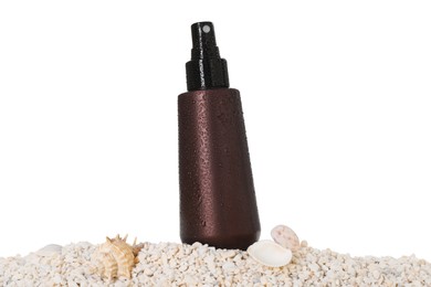 Bottle of sun protection product and seashells on pebbles against white background