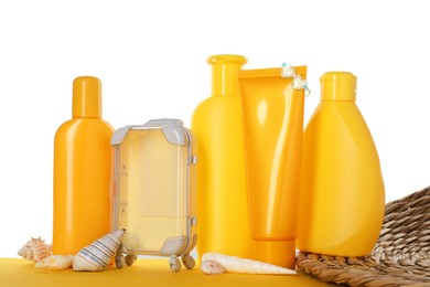 Photo of Different sun protection products and seashells on yellow surface against white background