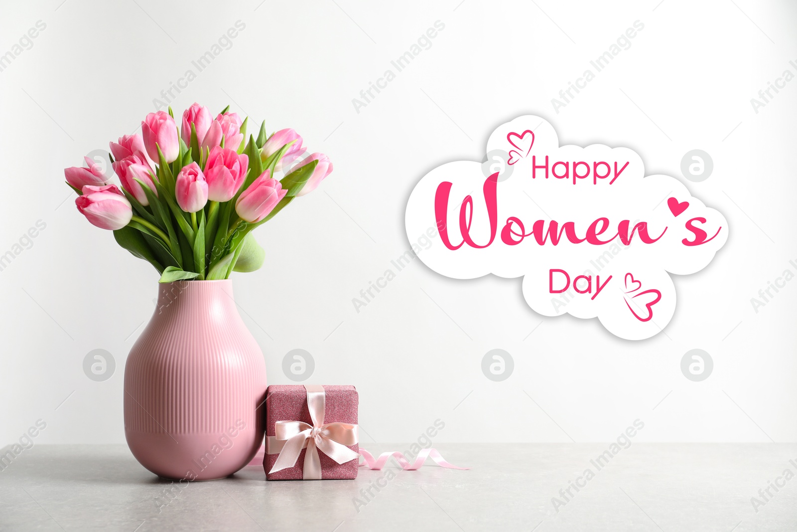 Image of Happy Women's day card. Vase with beautiful pink tulips and gift box on table