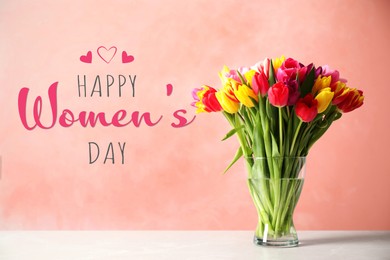 Happy Women's day card. Glass vase with beautiful bright tulips on table against coral background