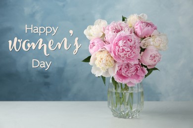 Image of Happy Women's day card. Glass vase with beautiful peonies on table against light blue background