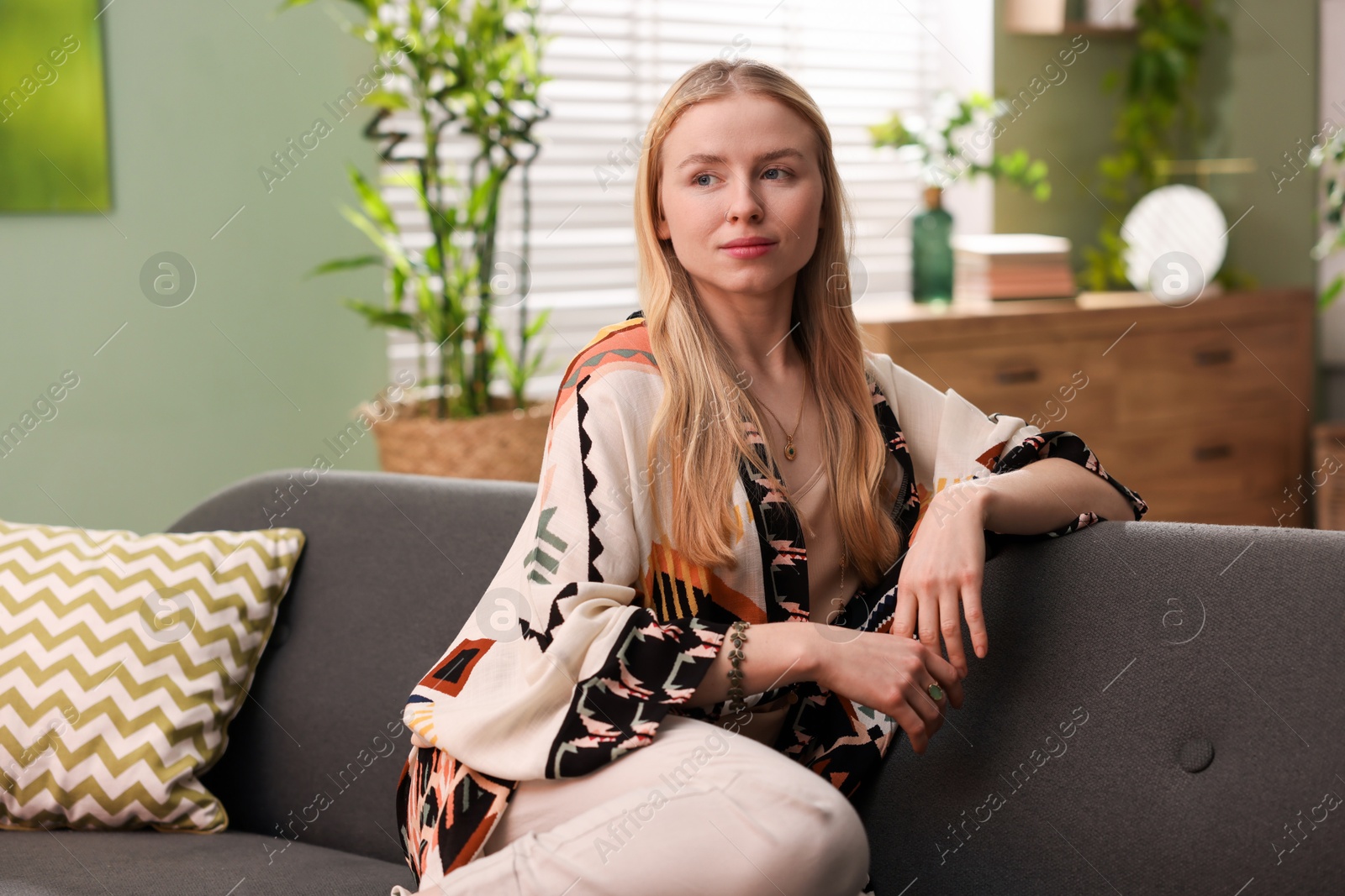 Photo of Feng shui. Young woman sitting on couch at home