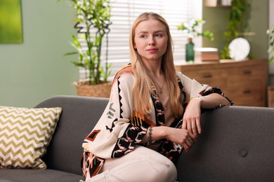 Feng shui. Young woman sitting on couch at home