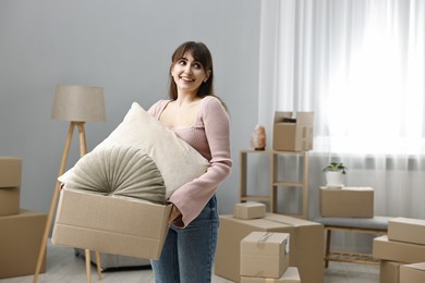 Photo of Moving day. Happy woman with her belongings in new home