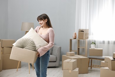 Moving day. Happy woman with her belongings in new home