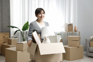 Moving day. Happy woman with her belongings in new home