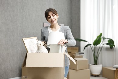 Moving day. Happy woman with her belongings in new home