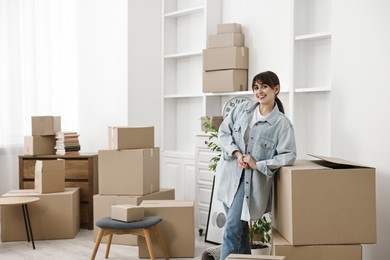 Moving day. Happy woman with her belongings in new home