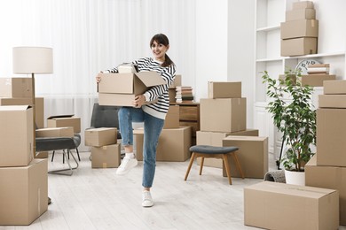 Moving day. Happy woman with her belongings in new home