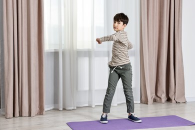 Little boy exercising at home, space for text. Morning routine