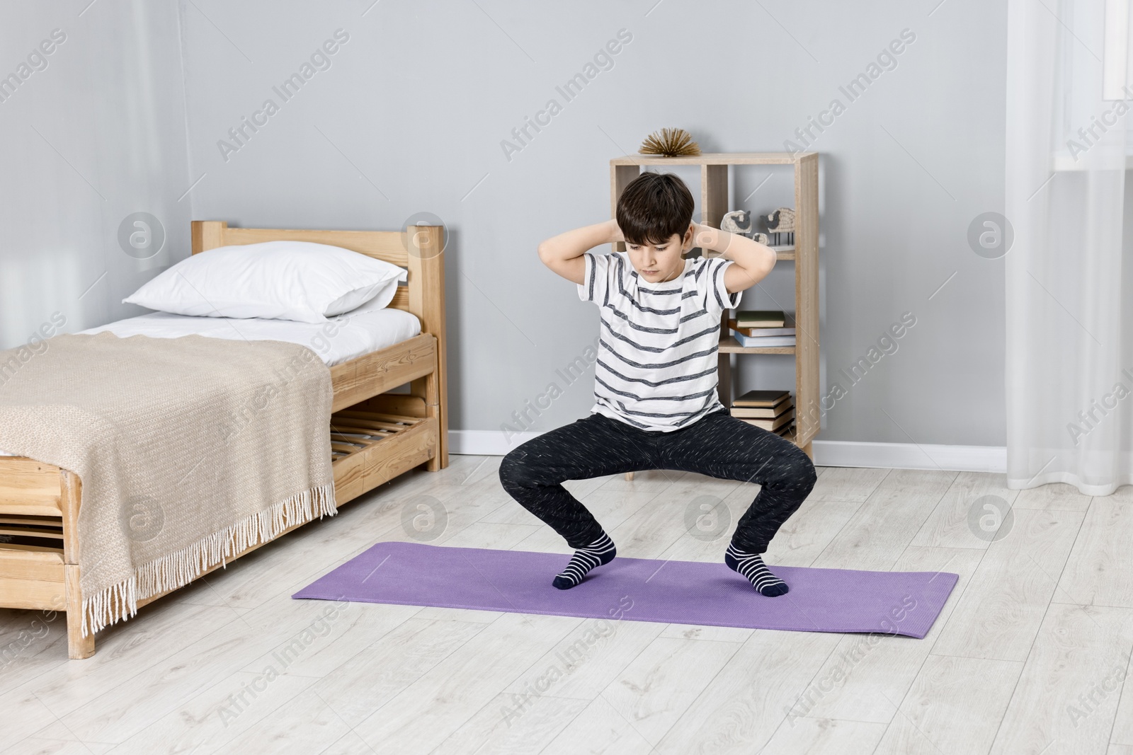 Photo of Little boy exercising at home. Morning routine