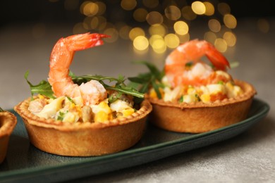 Tartlets with delicious filling on grey table, closeup. Bokeh effect