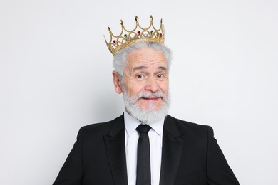 Senior man wearing luxury crown on white background