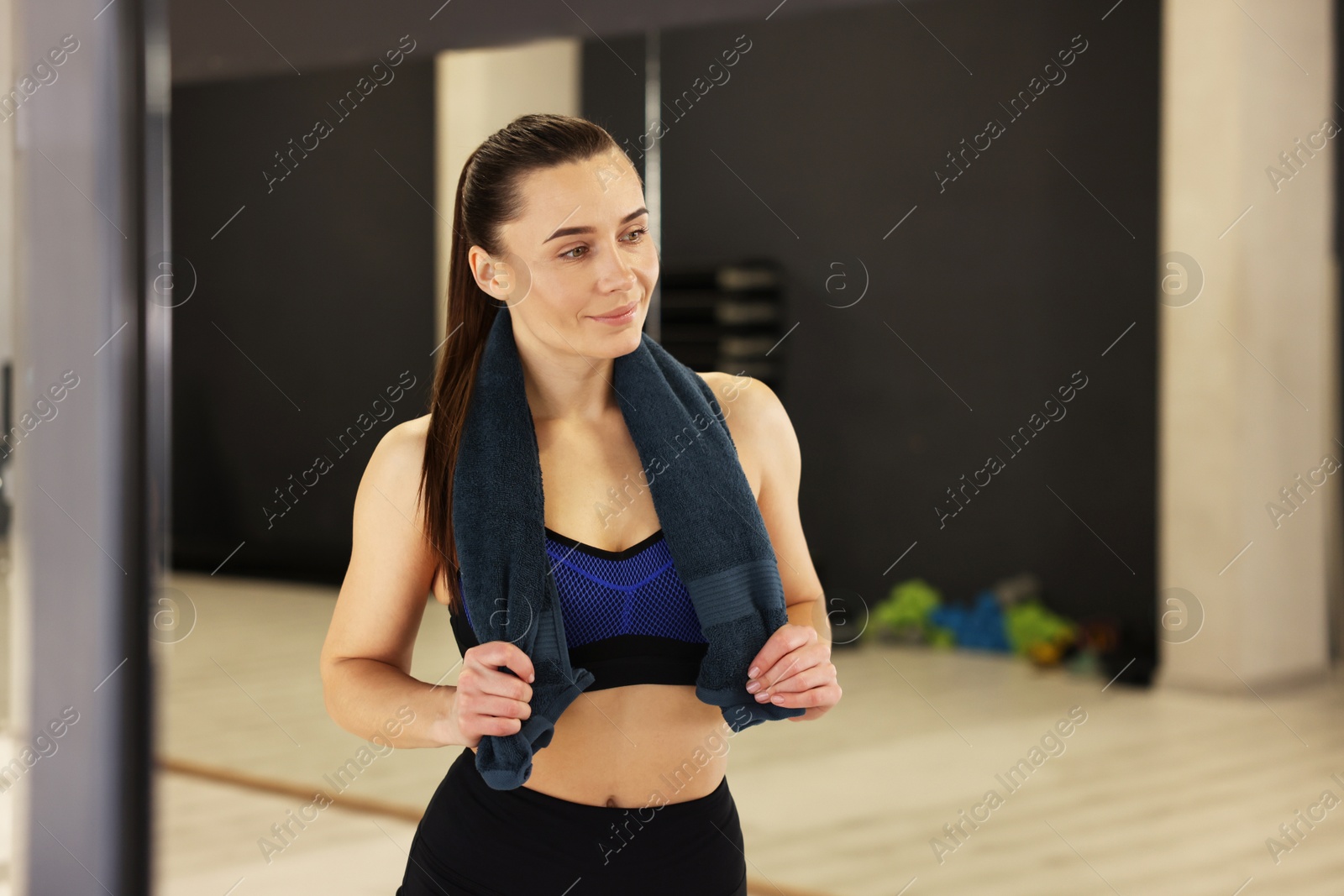 Photo of Happy woman with towel in fitness studio