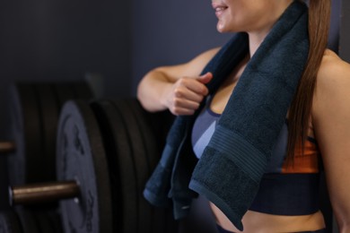 Happy woman with terry towel in gym