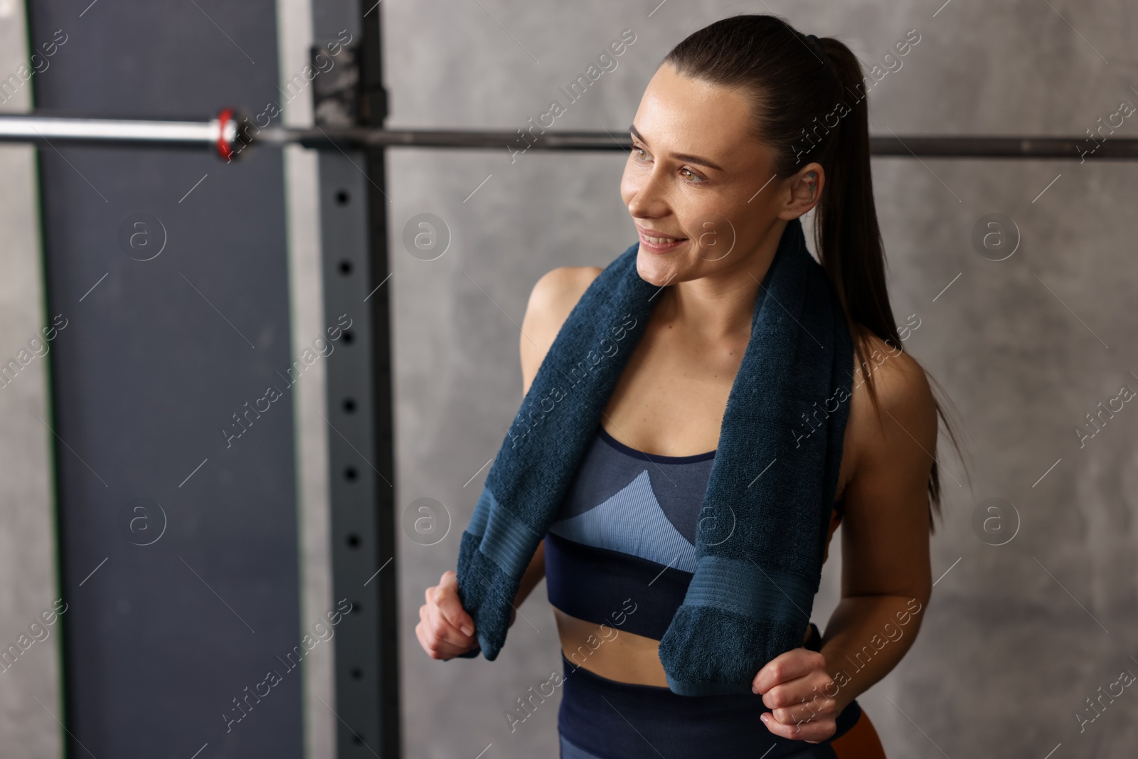 Photo of Happy woman with terry towel in gym