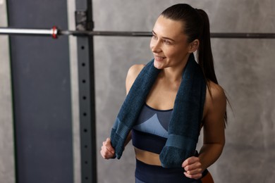 Happy woman with terry towel in gym