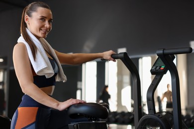 Happy woman with terry towel in gym