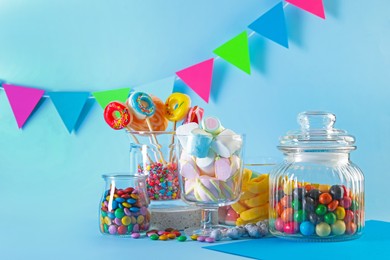 Photo of Candy bar. Many different sweets on light blue background. Space for text