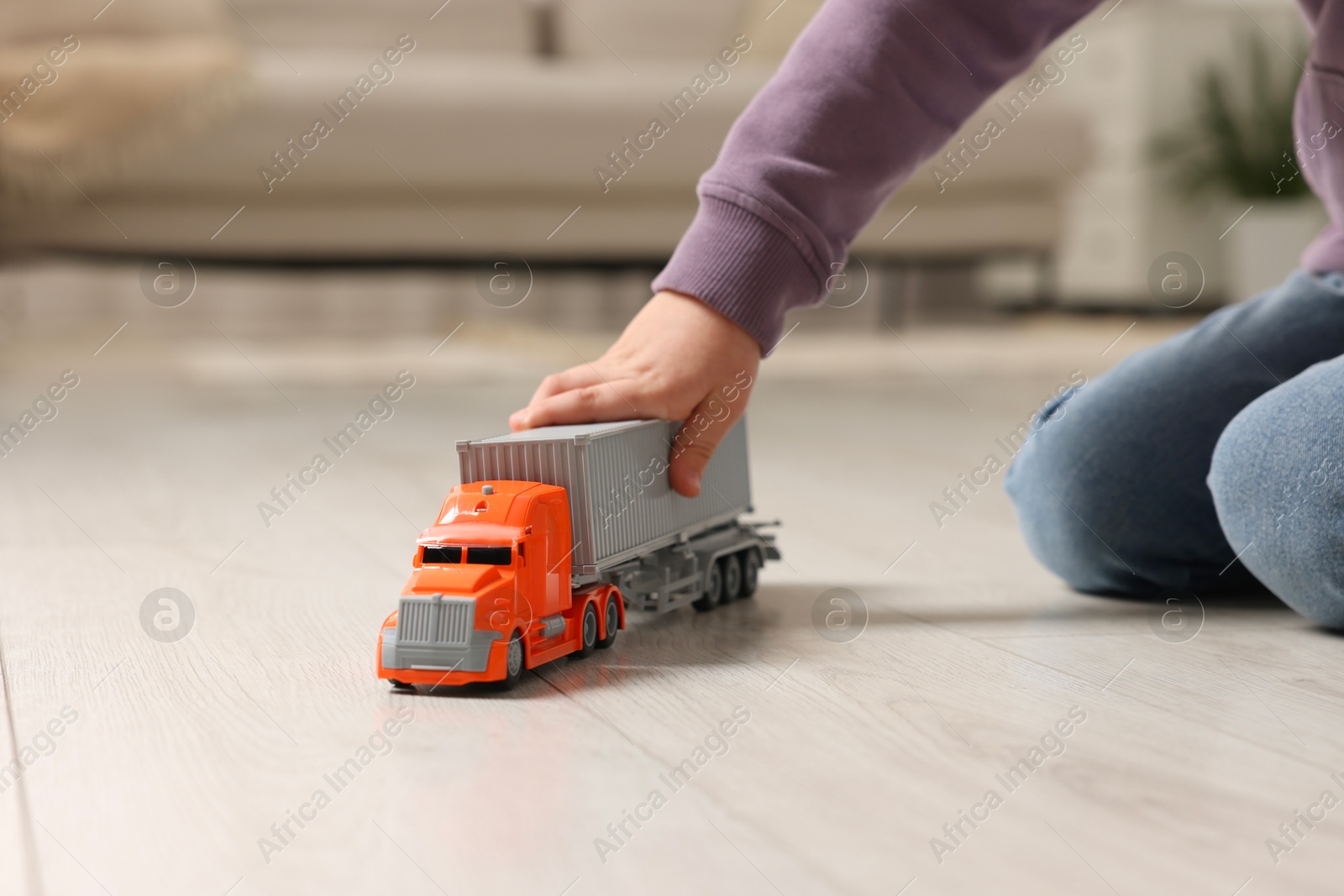 Photo of Little boy playing with toy car at home, closeup. Space for text