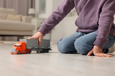 Little boy playing with toy car at home, closeup