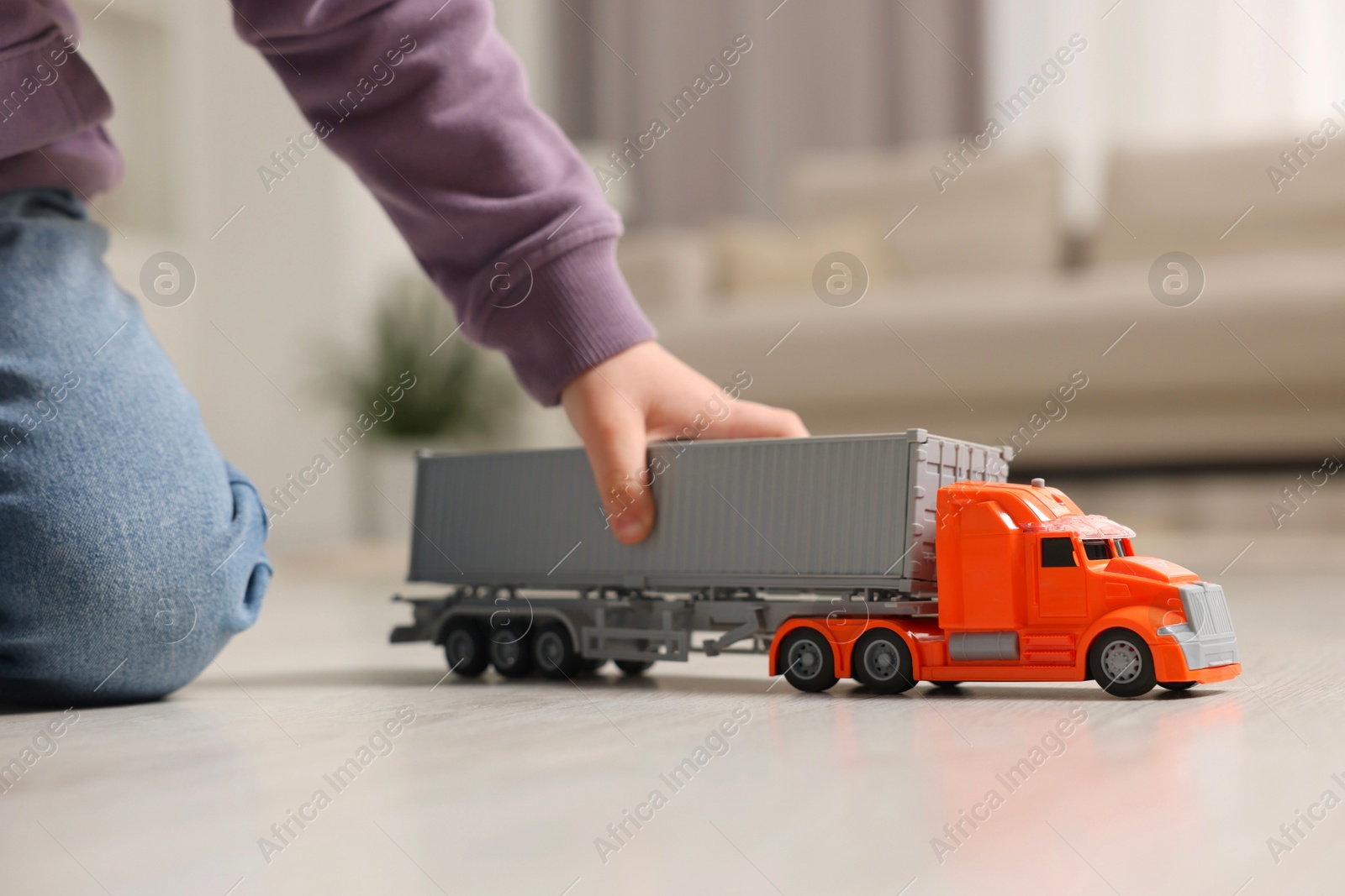 Photo of Little boy playing with toy car at home, closeup