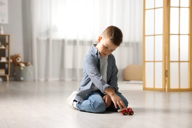 Little boy playing with toy car at home