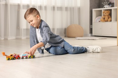 Photo of Little boy playing with toy cars at home