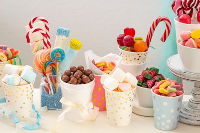 Photo of Candy bar. Different yummy sweets on white table against grey background